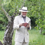 The author reading under a Birch tree during the book launch