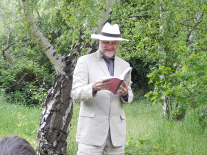 The author reading under a Birch tree during the book launch